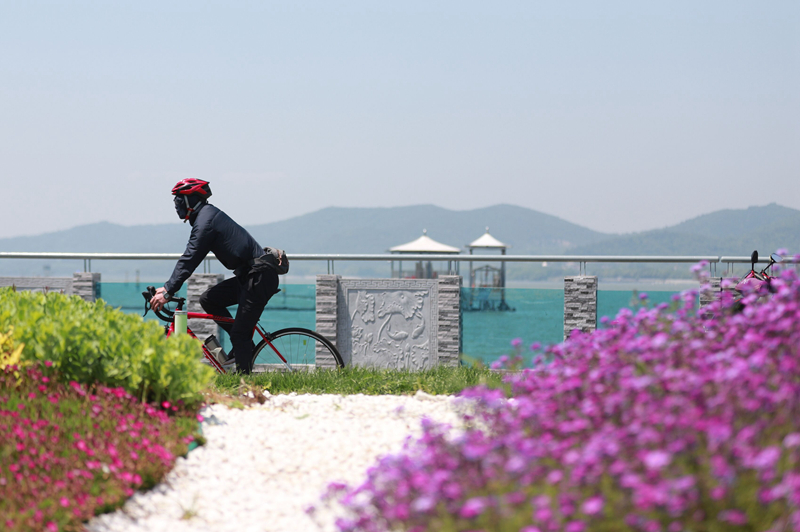 市民在風景如畫的環(huán)湖路上騎行